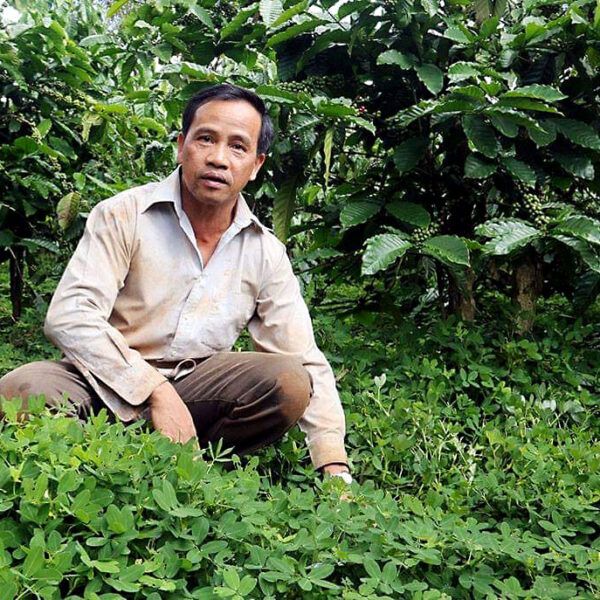 Mr. Vinh poses for a picture in his coffee farm, in Vietnam